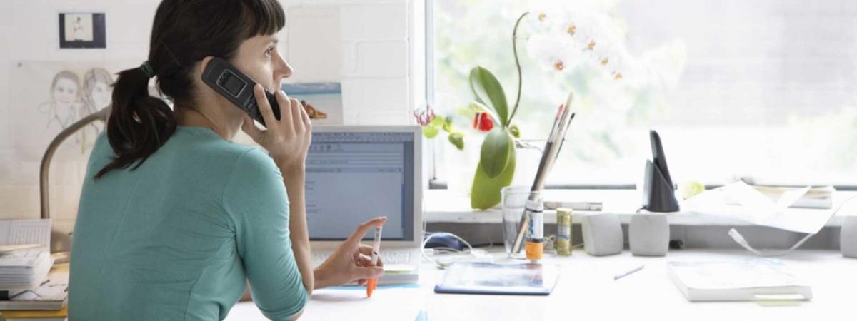 Woman at a desk while on the phone